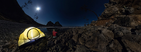 Cylindrical 360 panorama of  man at  tent on stone beach on shore of Lake Baikal at night.の写真素材