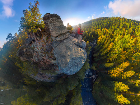 Backpacker on top of a rock fall at dawn. Wide angle aerial panorama.の写真素材