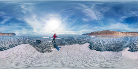 tourist with sleds walks along the blue ice of Lake Baikal. Spherical 360 degrees 180 panorama.の写真素材