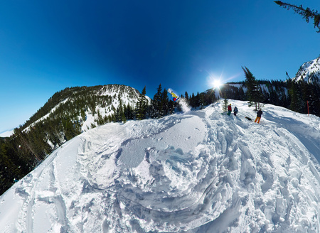 Snowboarder freerider jumping from snow ramp. Wide-angle aerial panorama.の写真素材