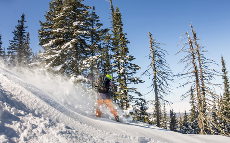 Snowboarder ride on powder snow to the mountains. Winter sports freeride.の写真素材