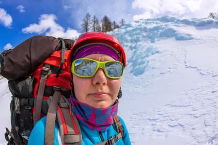portrait female mountaineer with backpack, helmet and harness with climbing in mountain.の写真素材