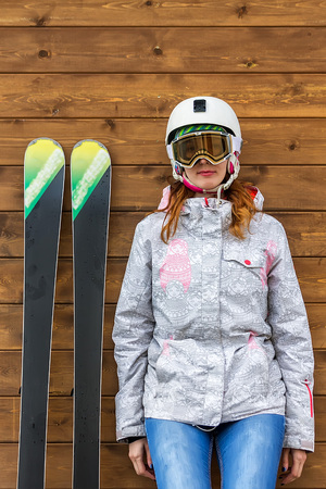 portrait woman skier with skis and helmet near wooden wall.の写真素材