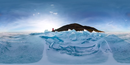 Woman in blue hummocks of the ice Baikal at sunset.の写真素材