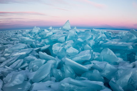 Pure transparent ice of Lake Baikal through the sun is shining in the sunset.の写真素材
