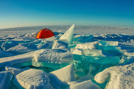 Orange tent stands alone among the ice hummocks and Lake Baikal.の写真素材