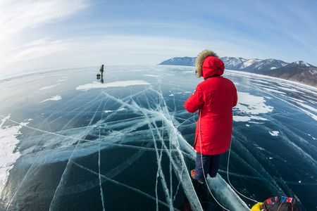 Woman with a sledge walk is on the ice of Lake Baikal.の写真素材