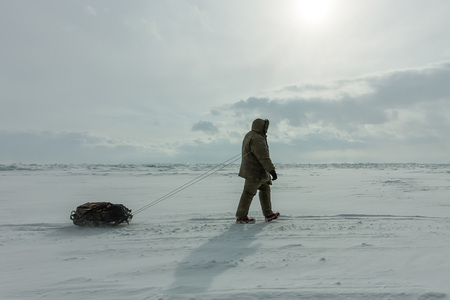 Woman with a sledge walk is on the ice of Lake Baikal.の写真素材