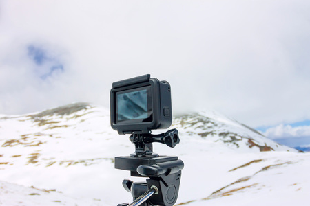 Action camera stands on a tripod against the backdrop of the mountains.の写真素材