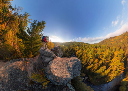 Backpacker on top of a rock fall at dawn. Wide angle aerial panorama.の写真素材