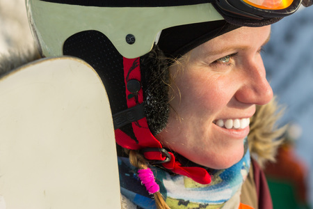 portrait of a snowboarder woman freerider in helmet in snowy mountains