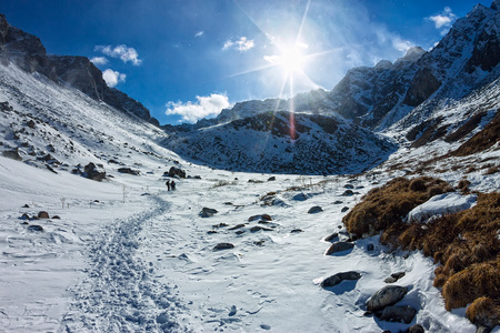 View from the valley to the top of the snowy mountains under the blue skyの写真素材