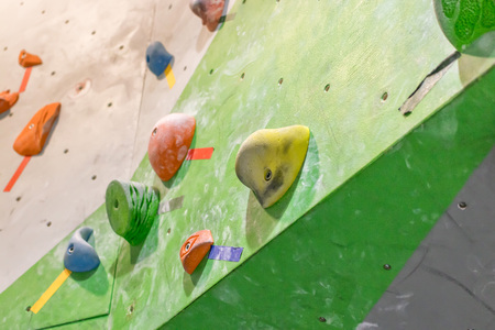 Climbing wall in the boulder hall with colored hooks