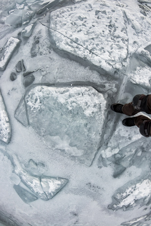 Human legs in hiking boot in ice crampons on the texture Baikal iceの写真素材