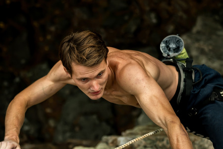 Rock climber climbs on a cliff on a rope, top viewの写真素材