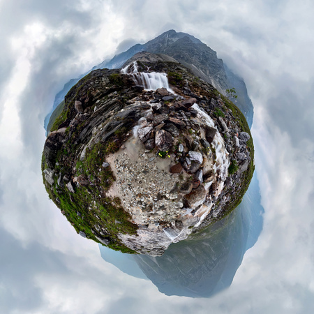 Mountain waterfall stream in misty rainy weather in the valley. Tiny little planet 360