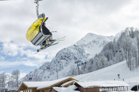 yellow chairlift on a background of snowy Caucasus mountains in winter. Ski resort Rosa Khutor.の写真素材