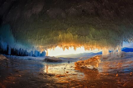sunset in a cave grotto with icicles in the winter on Olkhon Island, Lake Baikal