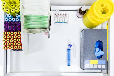 Test tubes and ampoules with blood tests on a table with a syringe and medical equipment. Positive COVID-19 test and laboratory sample of blood testing for diagnosis new Corona virus infectionの写真素材