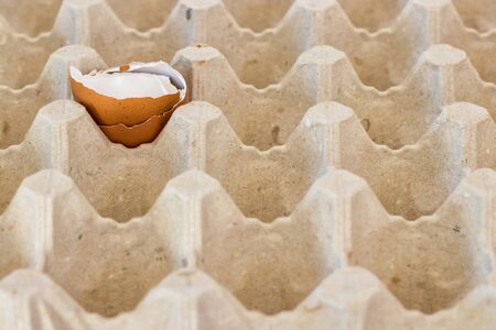 box with broken eggshell brown chicken eggs, background texture pattern