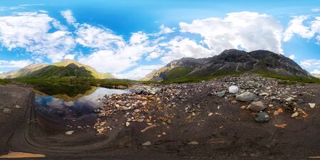 Transparent clear water of a mountain lake under a blue sky in the clouds. sand beach.Spherical panorama 360vrの写真素材
