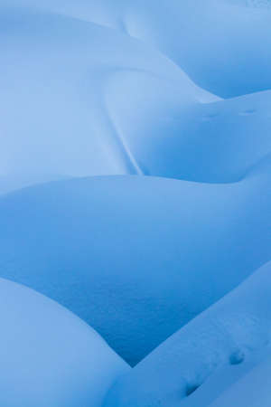 beautiful smooth lines texture of snowdrifts play of light and shadow of a winter landscape on the backgroundの写真素材