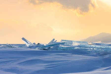 Transparent blue hummocks Baikal ice is shining through the crack sunset