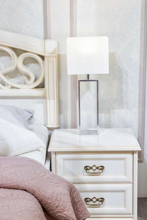 Bedroom interior, bed with pillows and blanket, lamp is on the bedside tableの写真素材