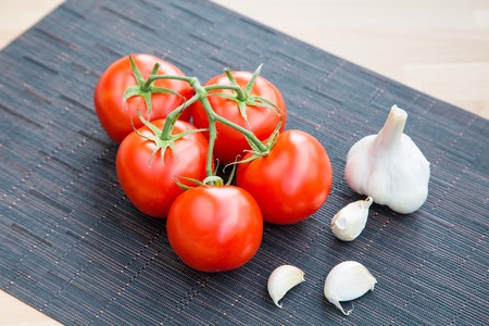 Fresh organic garlic and tomatos on the table still lifeの写真素材