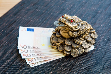 Money frog and euro banknotes  on the wooden tableの写真素材