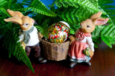 Two rabbits carrying Easter egg on green backgroundの写真素材
