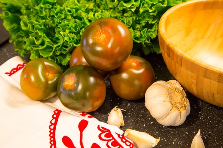 Tomatoes with lattuce, garlic and bamboo bowlの写真素材