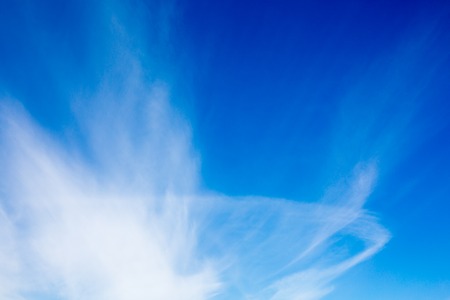 Deep blue sky with fluffy clouds backgroundの写真素材