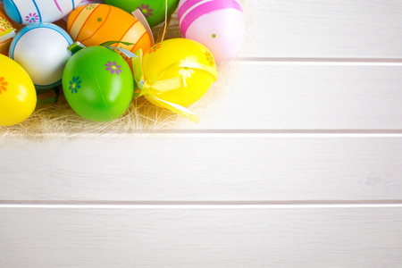 Green grass box with Easter eggs on the white wooden board backgroundの写真素材