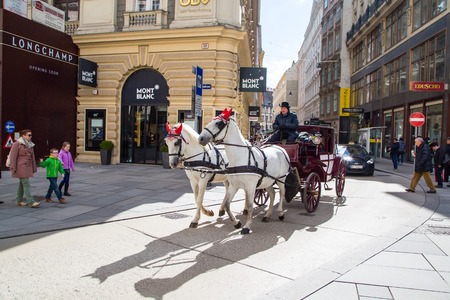 Vienna, Austria - April 3, 2015: City center Street view, people walking and fiacre with white horses  in Vienna, Austriaのeditorial素材