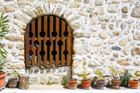 Wooden bars door, in an old medeval building and part of the  wall made of stonesの写真素材