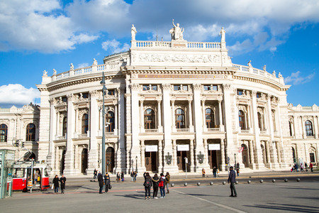 Vienna, Austria - April 3, 2015: Front facade of Burgtheater, red tram and people on the square, Vienna, Austria. Blue cloudy sky backgroundのeditorial素材