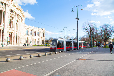Vienna, Austria - April 3, 2015: Part of Front facade of Burgtheater, red tram and people walking, Vienna, Austria.のeditorial素材