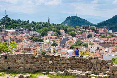 Plovdiv, Bulgaria - May 10, 2015: Couple sitting at the ruins of the old fortress and looking at Cityscape of Plovdiv city, Bulgariaのeditorial素材