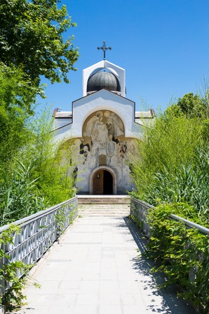 Front view of St Petka of Bulgaria, Baba Vanga's church in Rupite, Bulgaria and the path to it through the bridge and green plantsの写真素材