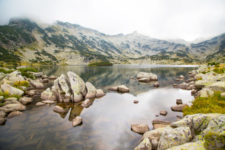 Background with Popovo lake at Bezbog in Bulgaria and mountains in the fogの写真素材