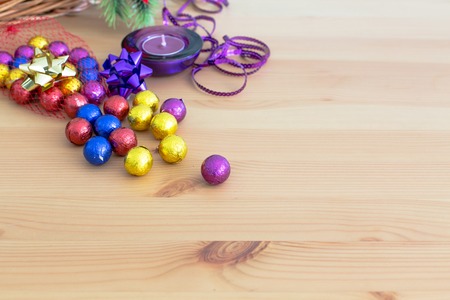 Still life with Christmas holiday decoration, purple and yellow golden sweet candy balls, candle ...