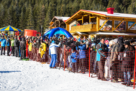 Bansko, Bulgaria - December, 12, 2015: Opening new ski season 2015-2016 in Bansko, Bulgaria. People watching th ceremony. Mountains and wooden cafe.のeditorial素材