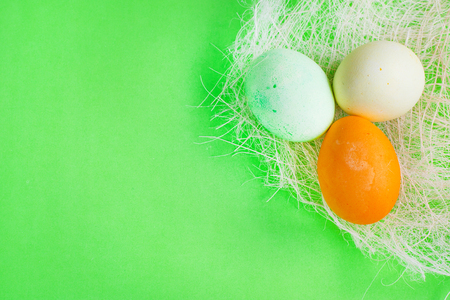 Green, yellow and orange Easter eggs on vibrant green backgroundの写真素材