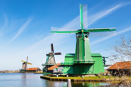 Windmill row in Zaanse Schans, traditional village in Netherlands, North Holland against blue cloudy skyの写真素材