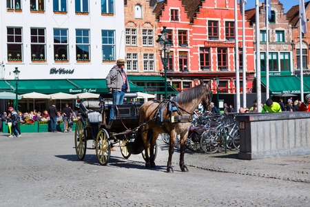 Bruges, Belgium - April 10, 2016:  Fiaker with brown horse waiting for tourists in popular belgian destination Brugge, Belgiumのeditorial素材