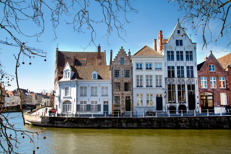 Bruges, Belgium - April 10, 2016: View with canal and colorful traditional houses against cloudy blue sky in popular belgian destination, Brugge, Belguimのeditorial素材