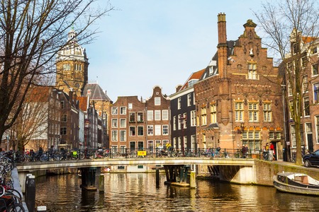 Amsterdam, Netherlands - April 2, 2016: Traditional old buildings, church, canal and bridge view with bicycles in Amsterdam, the Netherlandsのeditorial素材