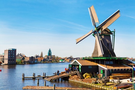 Zaanse schans, Netherlands - April 1, 2016: Windmill in Zaanse Schans, North Holland, traditional village, tourists, blue skyのeditorial素材