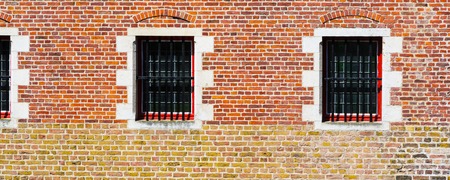 Windows of traditional medieval house exterior on red brick wall in Brugge, Belguim, panoramic backgroundの写真素材